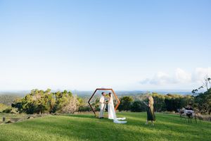 Wedding couple posing on a hilltop with panoramic mountain views.