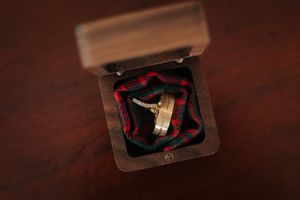 Wedding rings displayed on dark wooden surface.