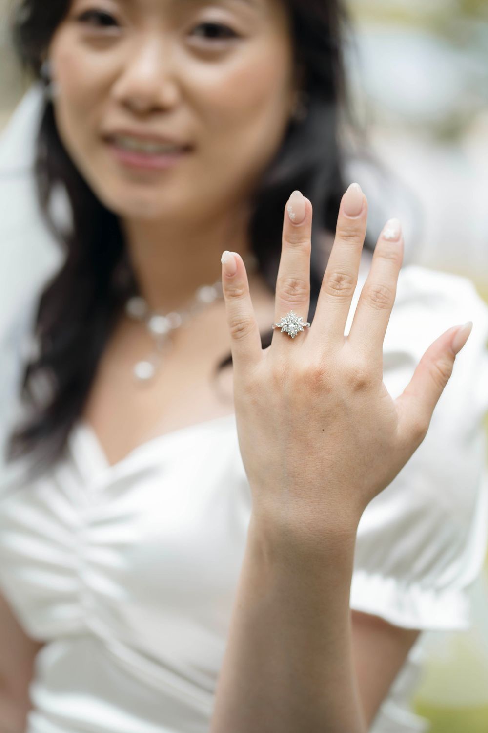 A series of photos showing hands displaying an engagement ring from different angles in natural lighting.