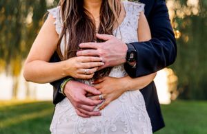 Close-up of couple's hands embracing in romantic wedding pose.