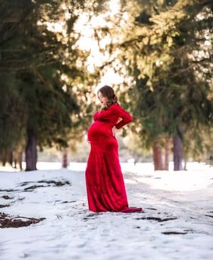 Flowing red dress creates elegant silhouette against snowy winter landscape.