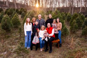 Large group poses for sunset photo at Christmas tree farm.