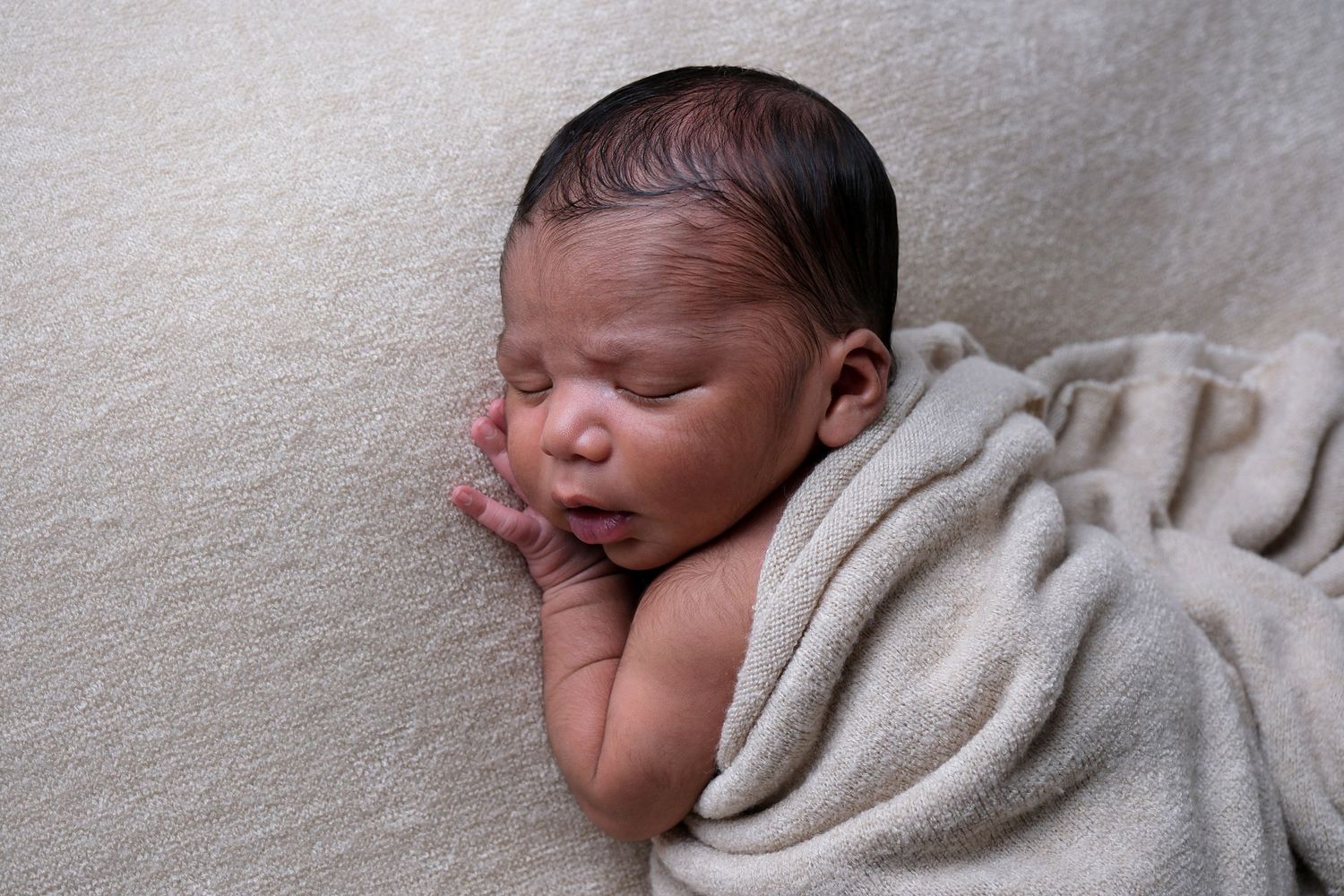 Newborn baby posed on front with wrap during newborn photography session