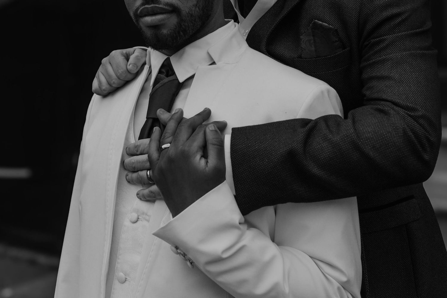 Black and white image of a newly married couple holding tightly onto each other.