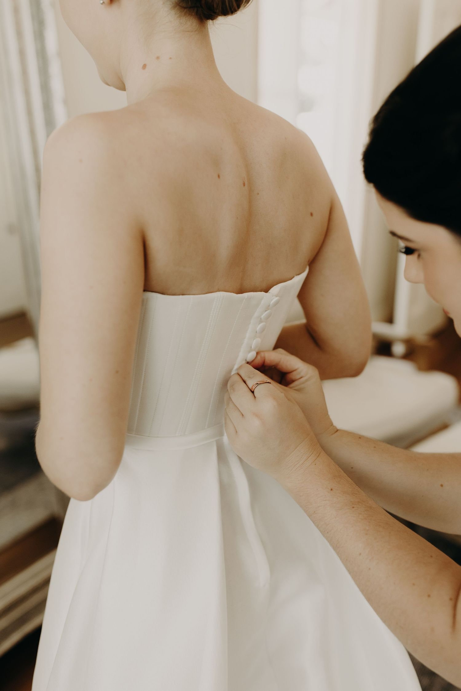 Back view of white wedding dress details showing elegant strapless design.