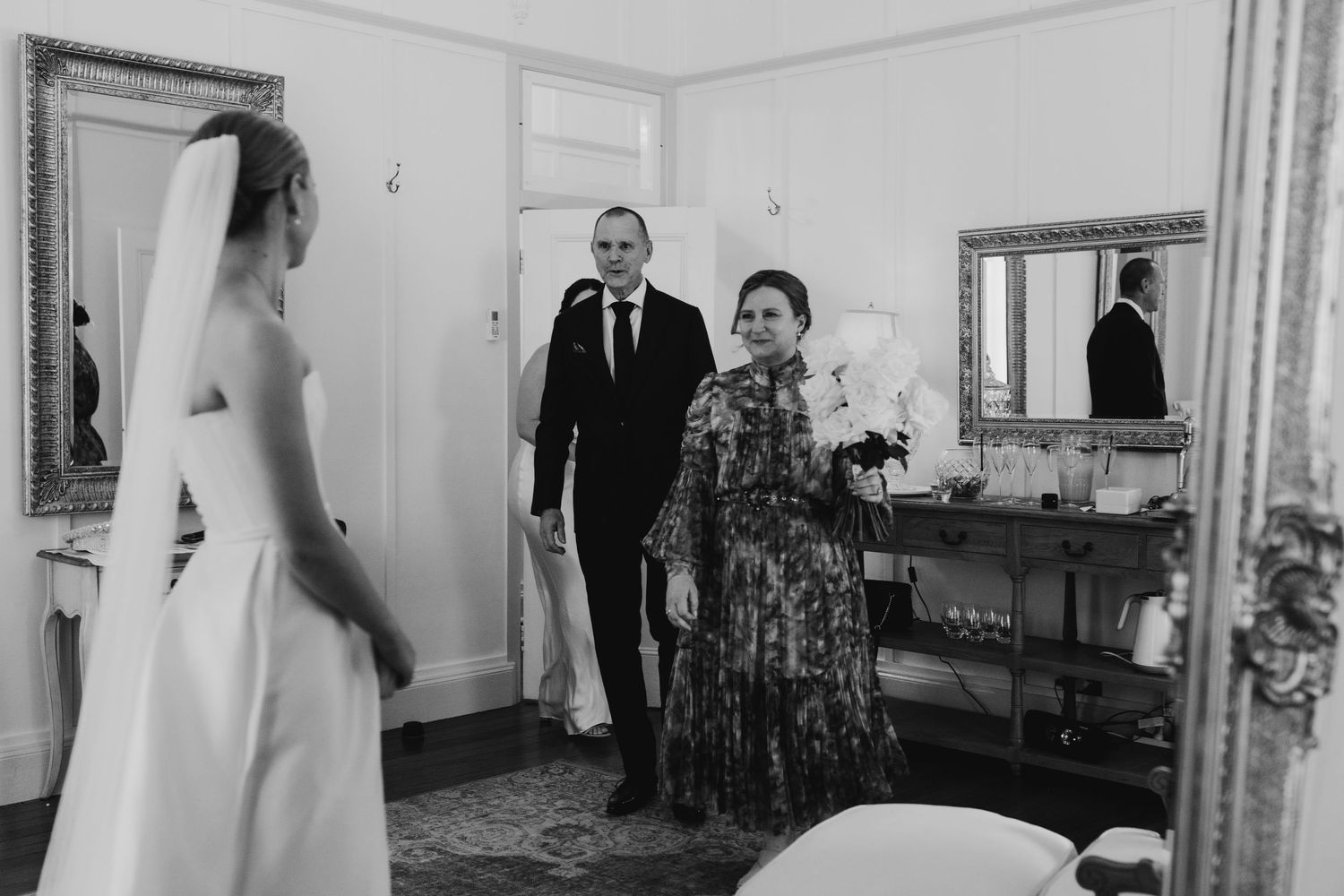 Wedding preparation moments captured in a bright interior room with vintage decor.