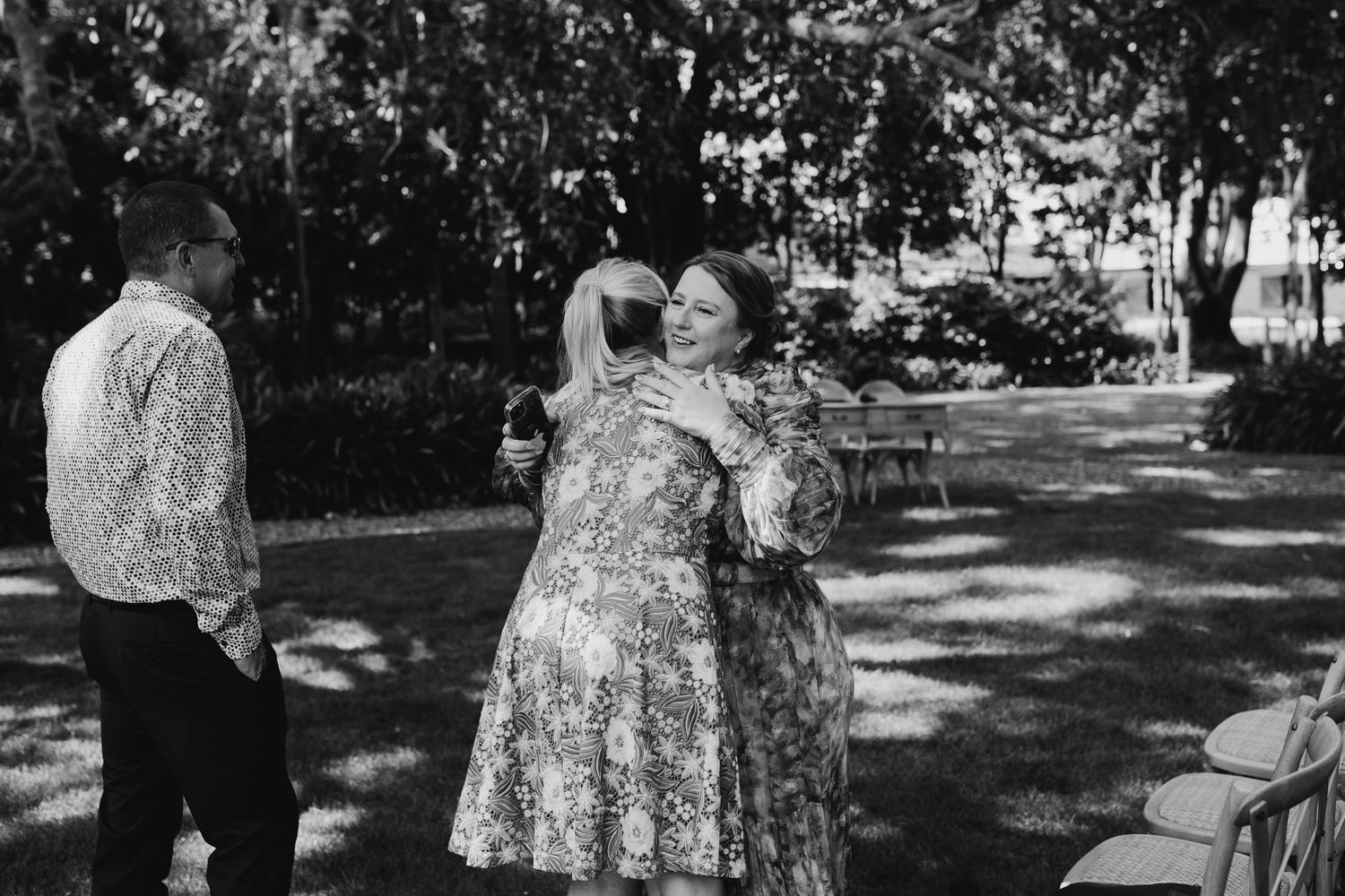 Outdoor wedding party candids in black and white with natural garden setting.
