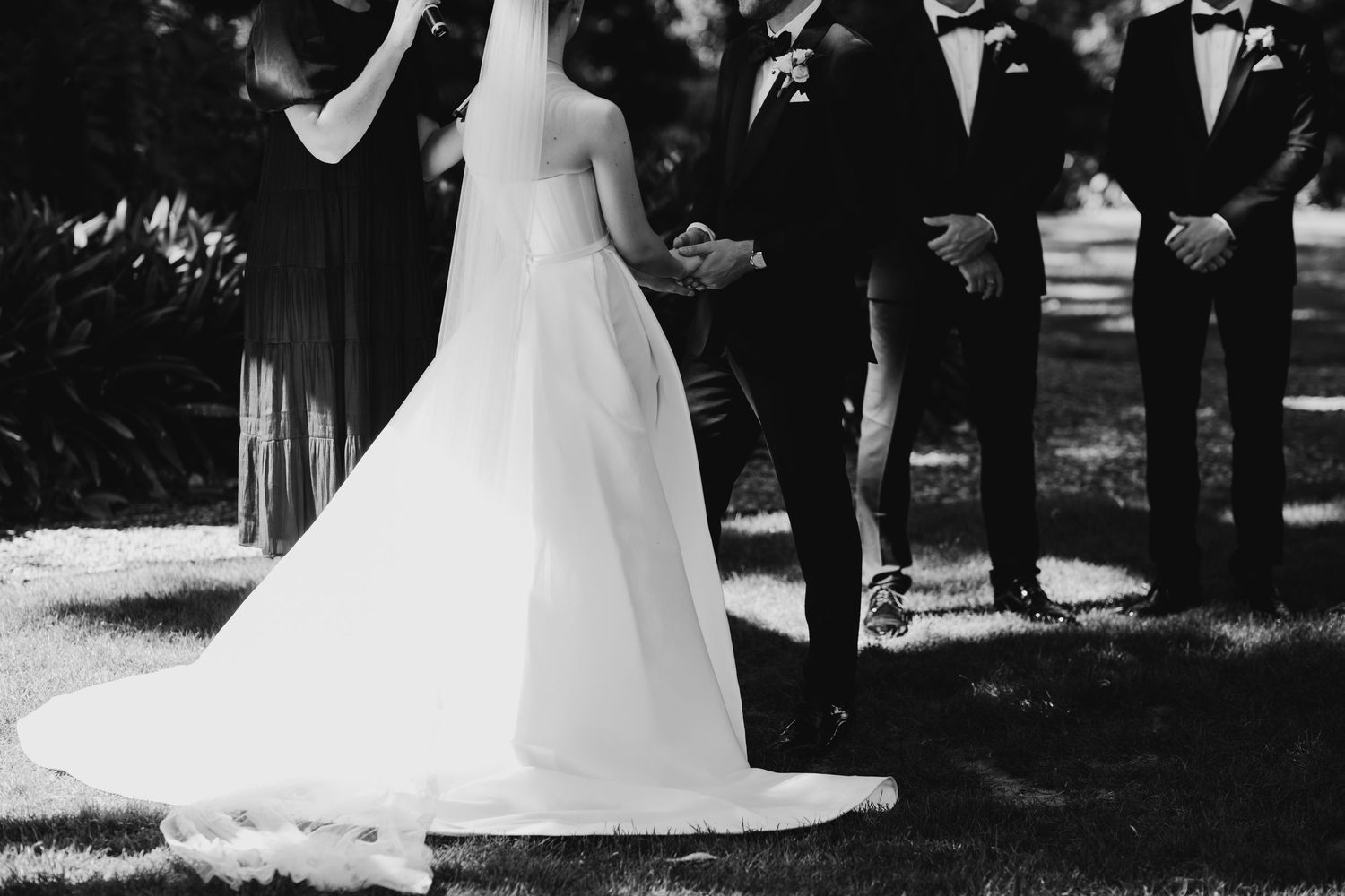 Black and white wedding ceremony moments captured in natural outdoor setting.
