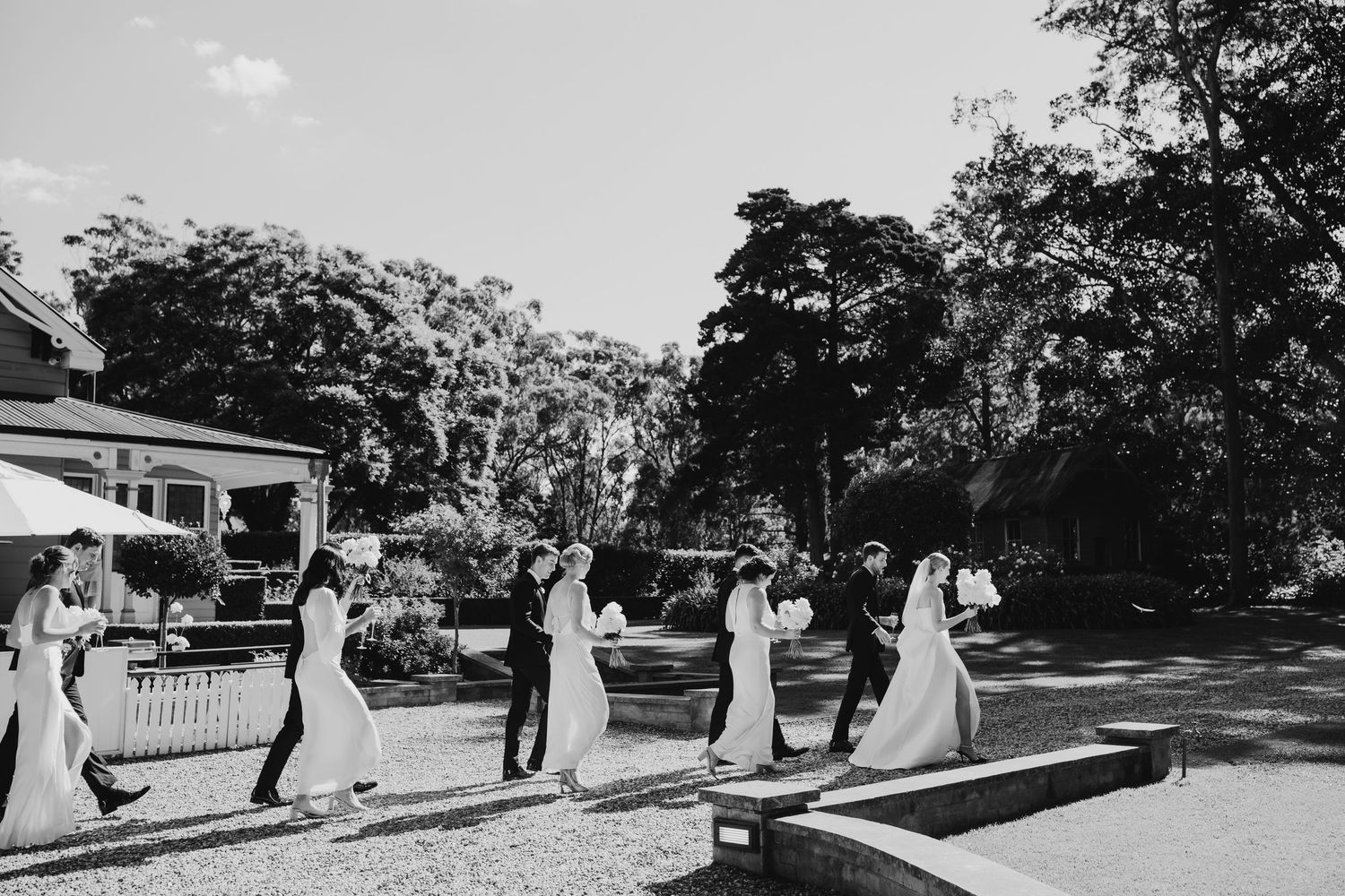Black and white photo of wedding guests enjoying outdoor reception activities.