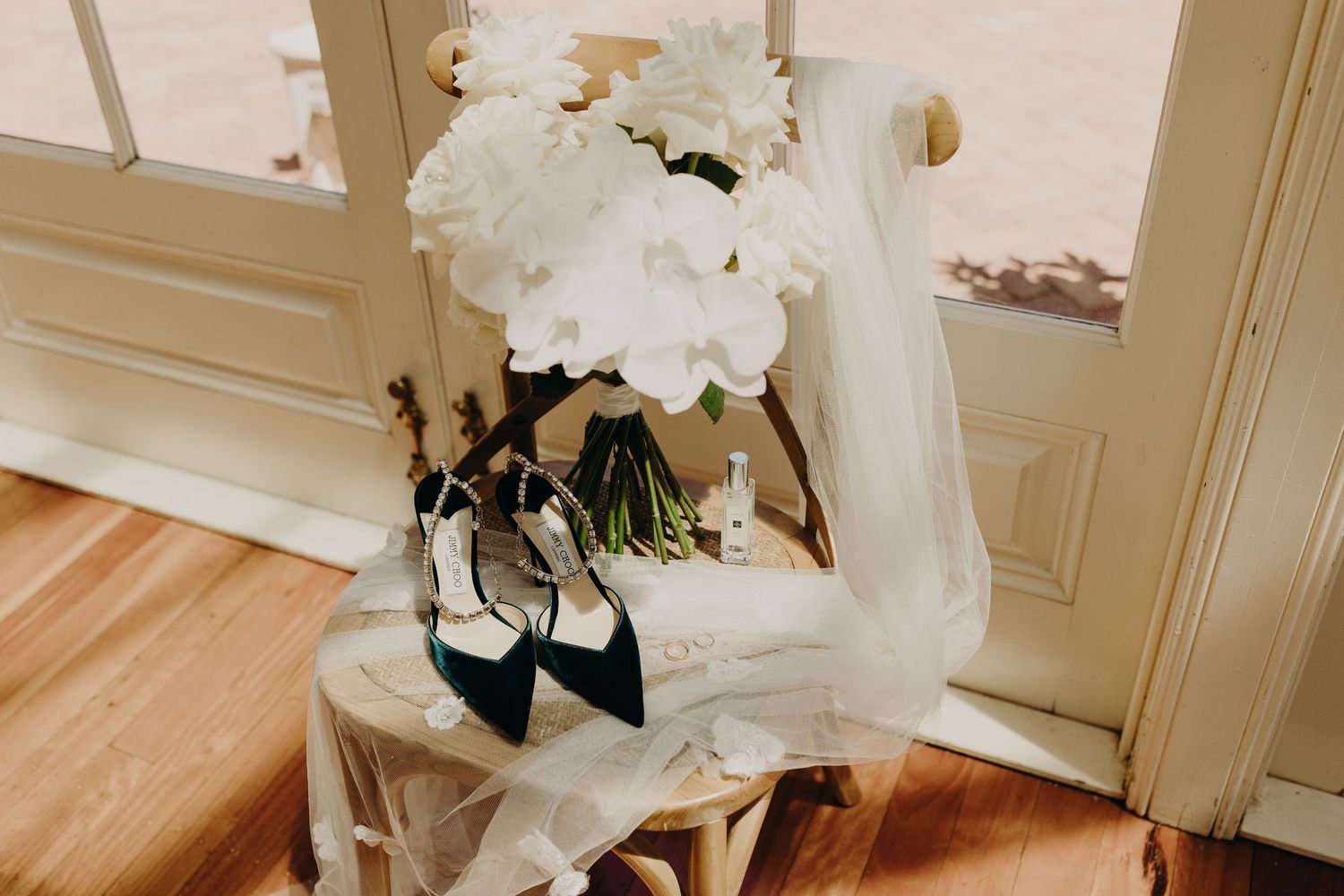 White floral bouquets and decor arranged elegantly on wooden tables for a wedding celebration.