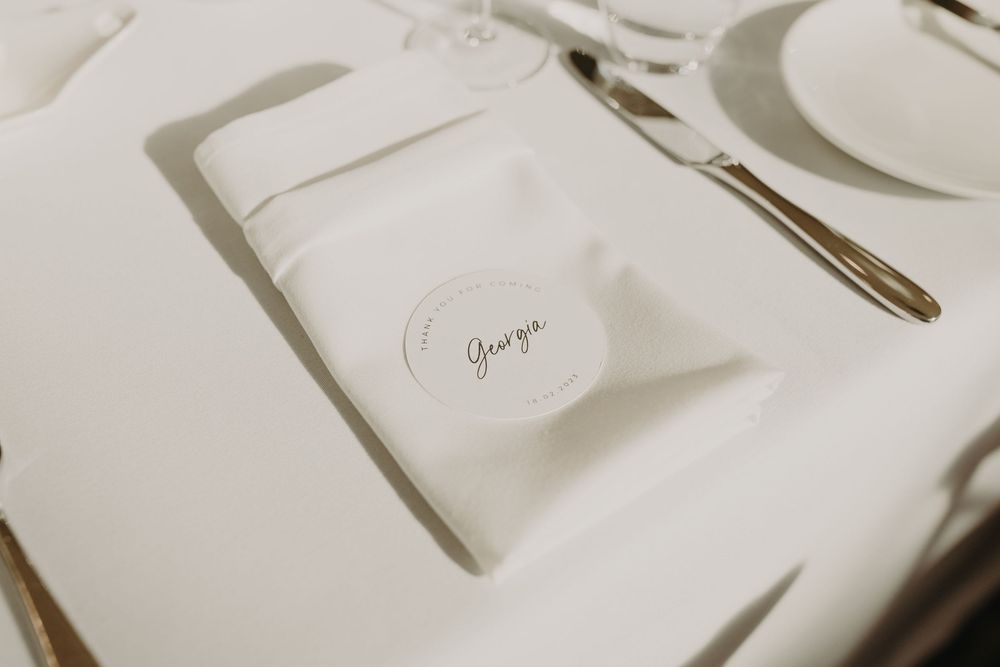 Close-up of elegant place setting with white napkin and silverware on formal dining table.