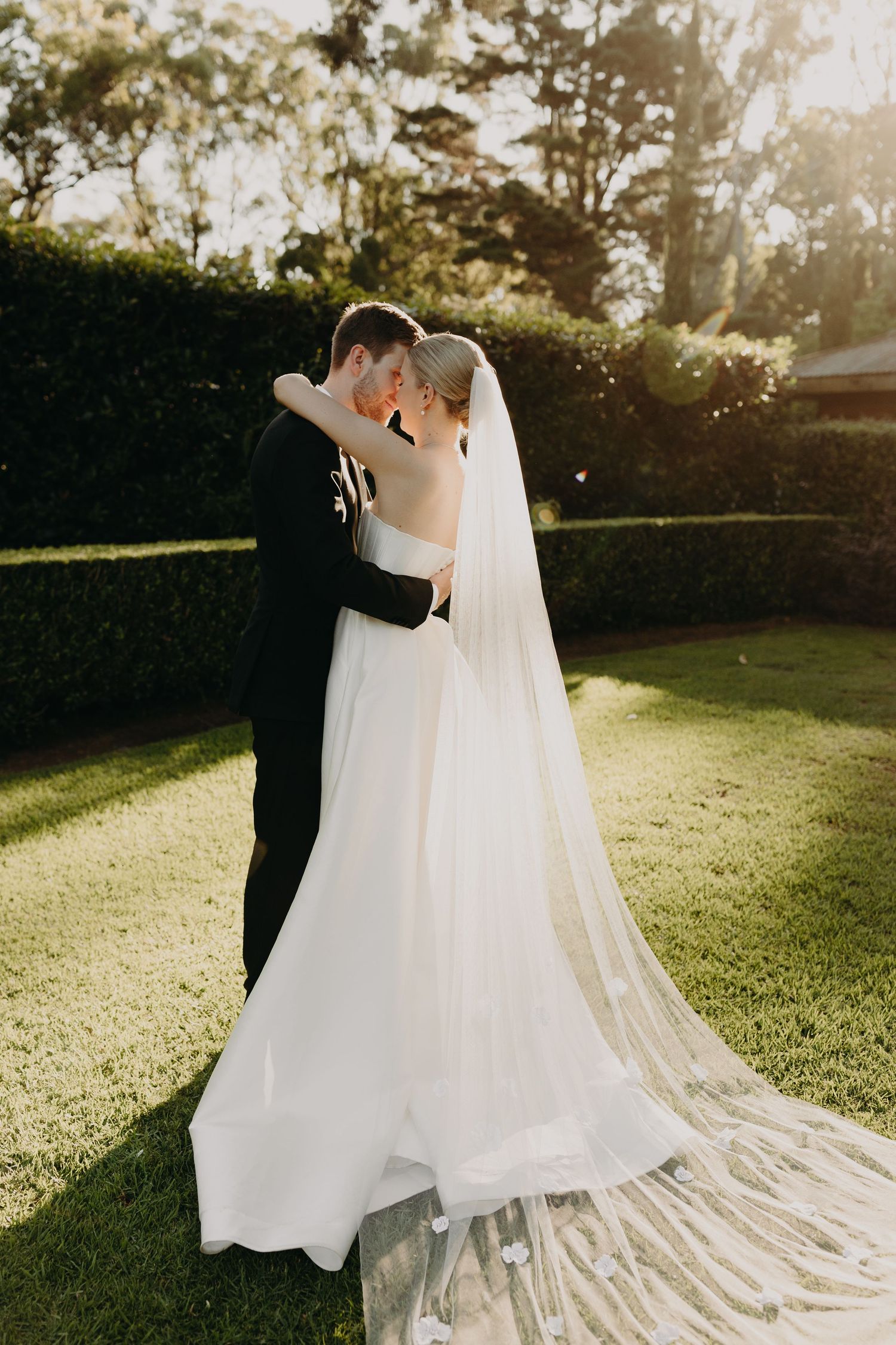 A couple shares an intimate dance moment during their wedding photoshoot at sunset.