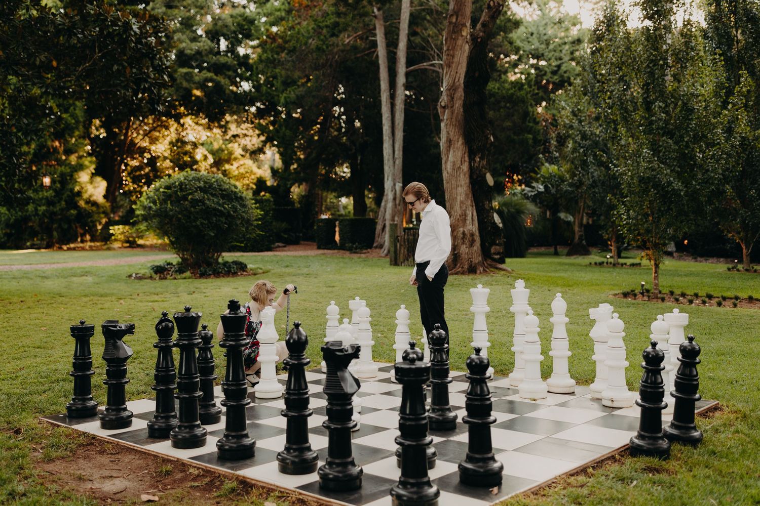 Large outdoor chess pieces create a unique backdrop for a wedding photo session.