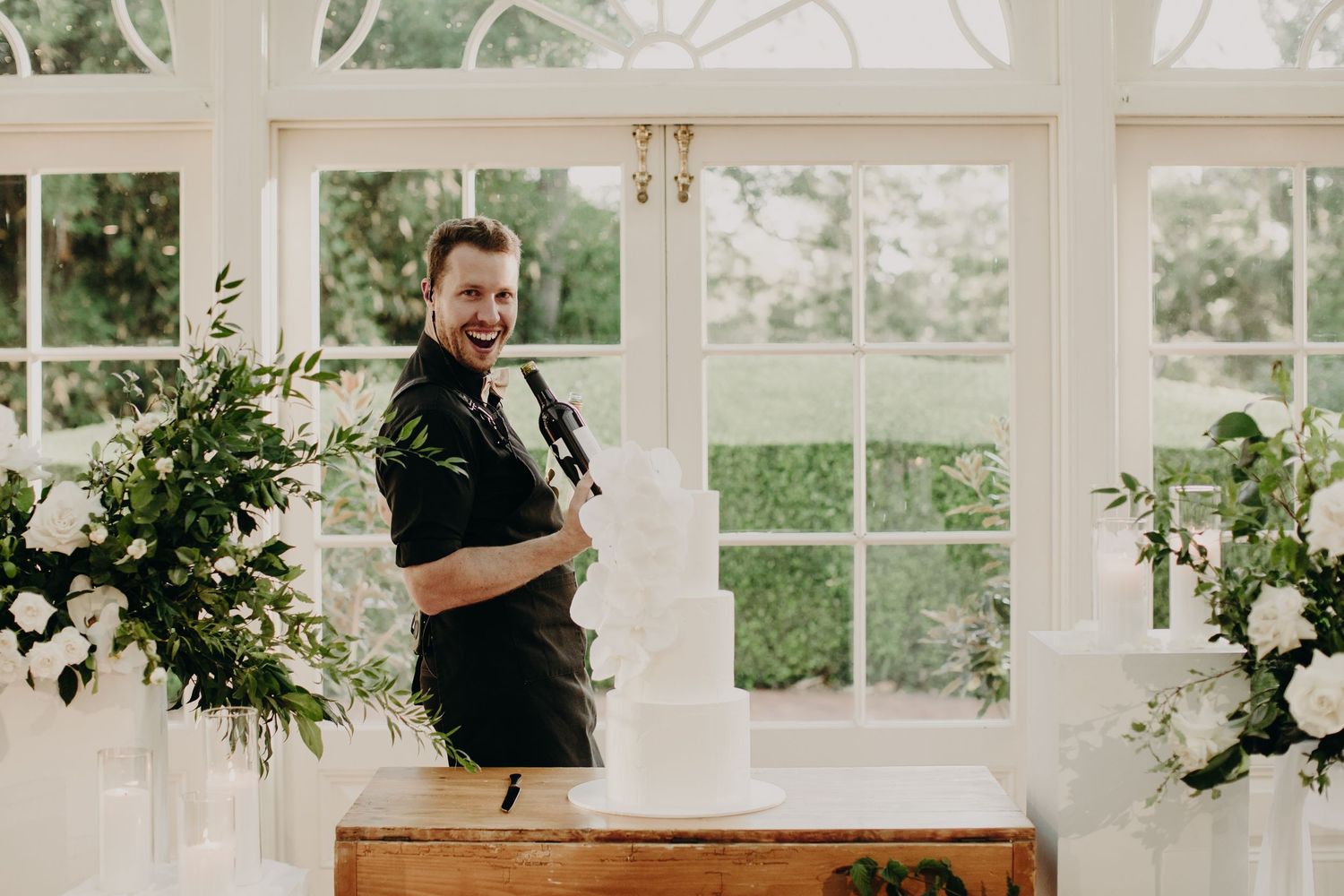 Modern conservatory wedding venue with white decor and natural light streaming through windows.