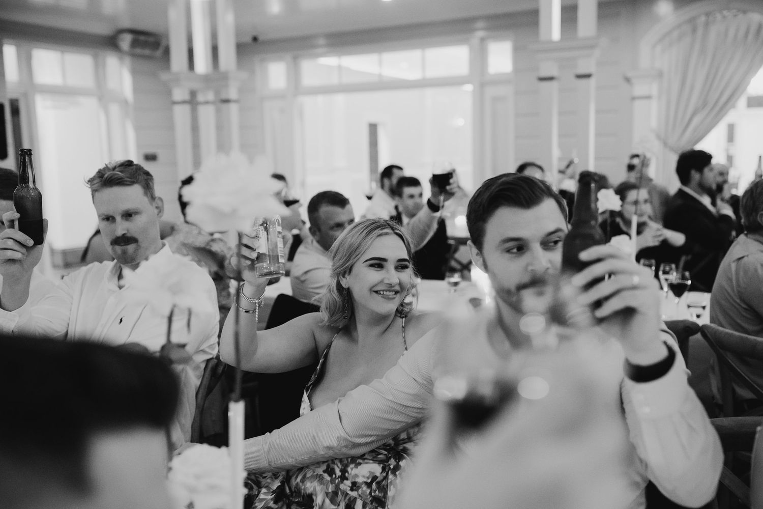 Wedding guests raise their phones to capture a moment during the reception celebration.