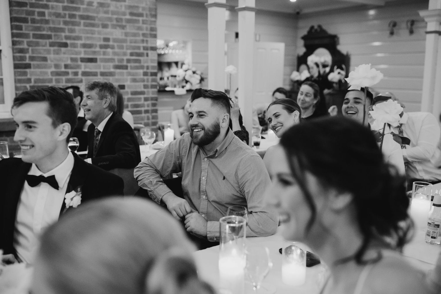 Black and white photo of guests enjoying themselves at a wedding reception.