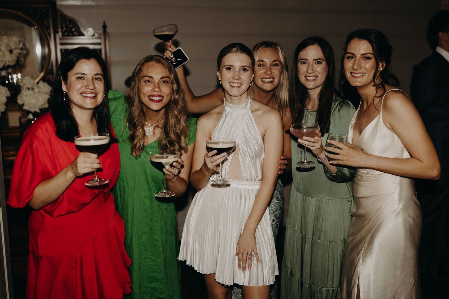 Group celebration with attendees in coordinated green and red attire.