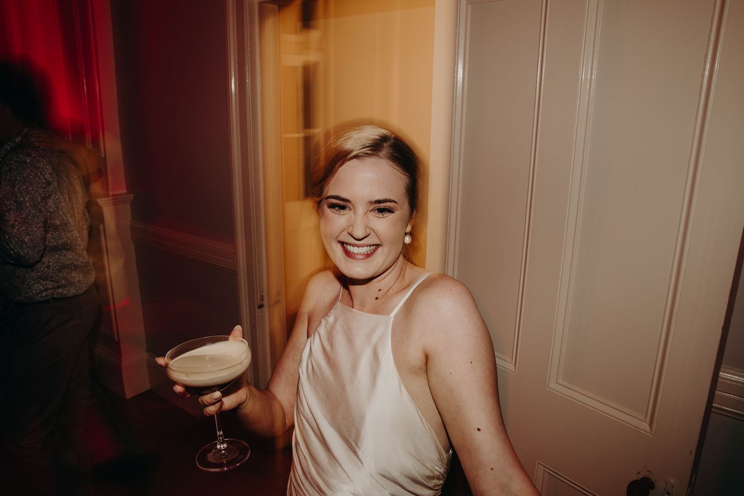 Wedding celebration in a warm-lit room with red ambient lighting.
