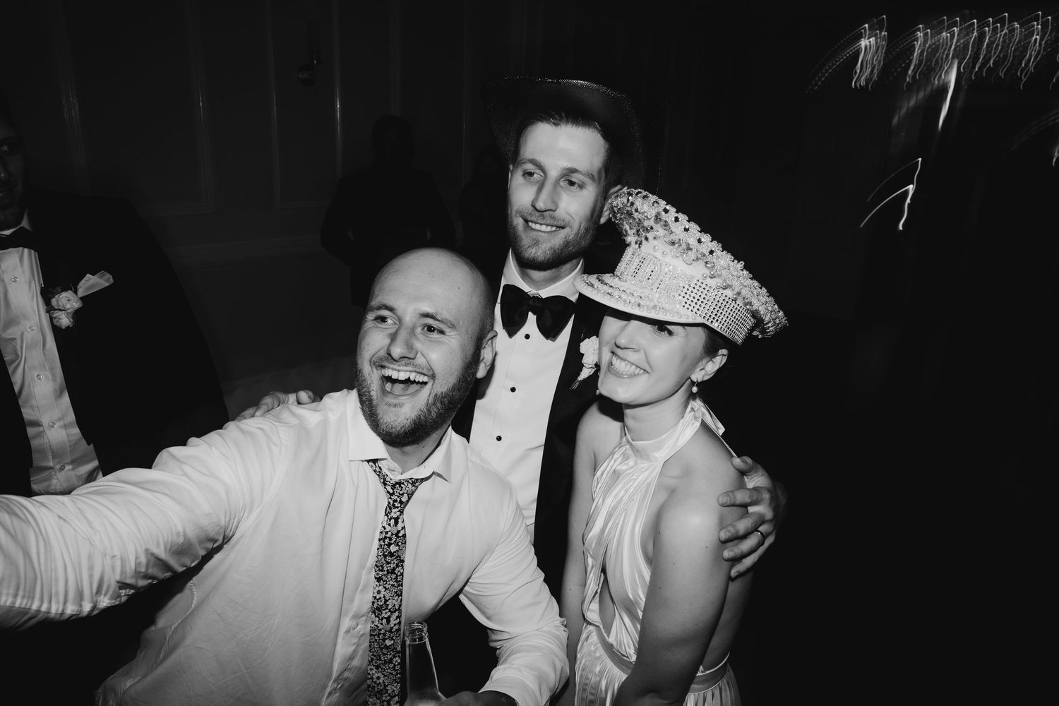 Black and white photo of guests celebrating at a lively wedding reception.