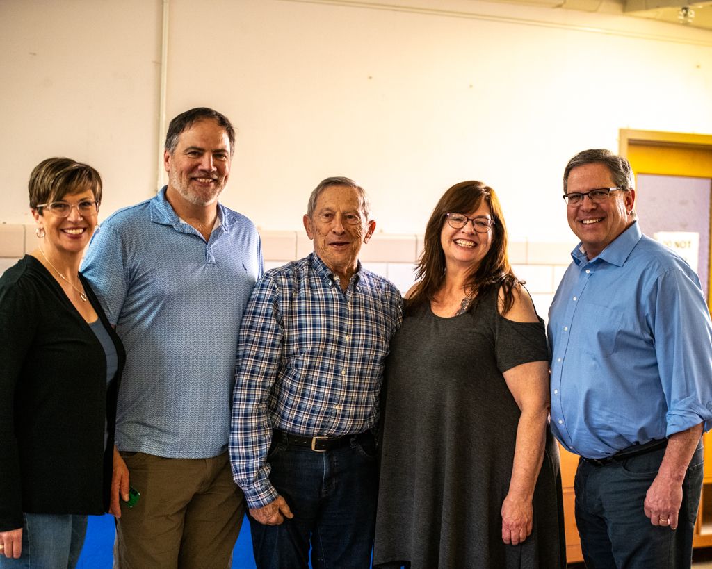 Group photo session indoors with people standing together in casual clothing.