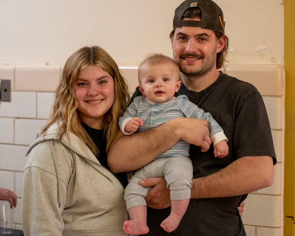 Family portrait session featuring casual indoor poses in a warm setting.