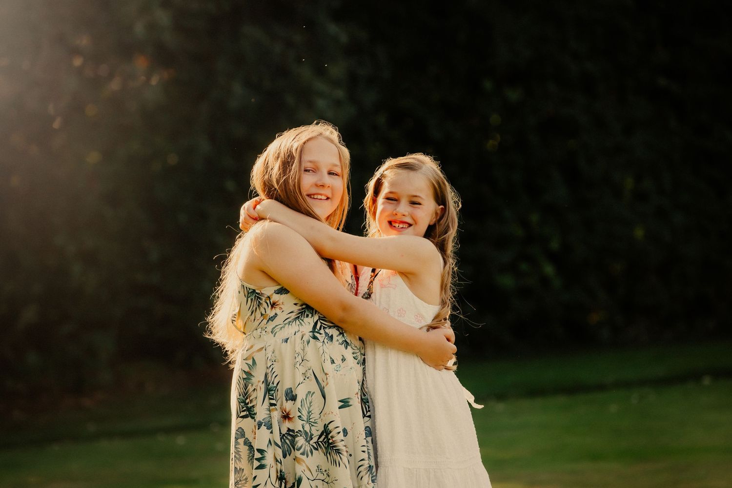A middle aged couple hold hands and walk through a meadow in Chichester while laughing during a family photography shoot