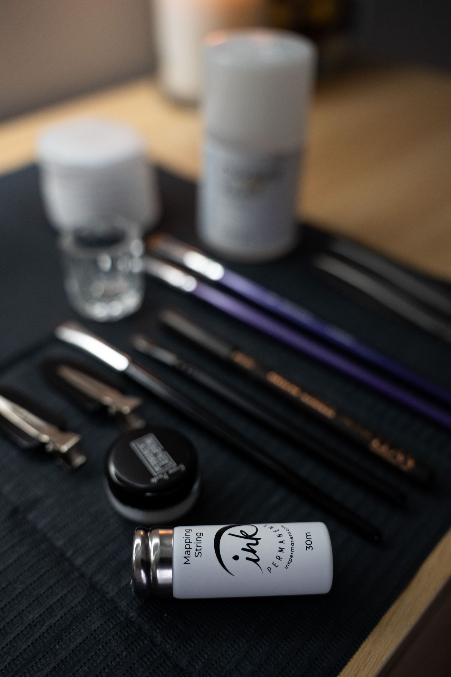 Professional makeup brushes and beauty products arranged on a dark surface with selective focus.