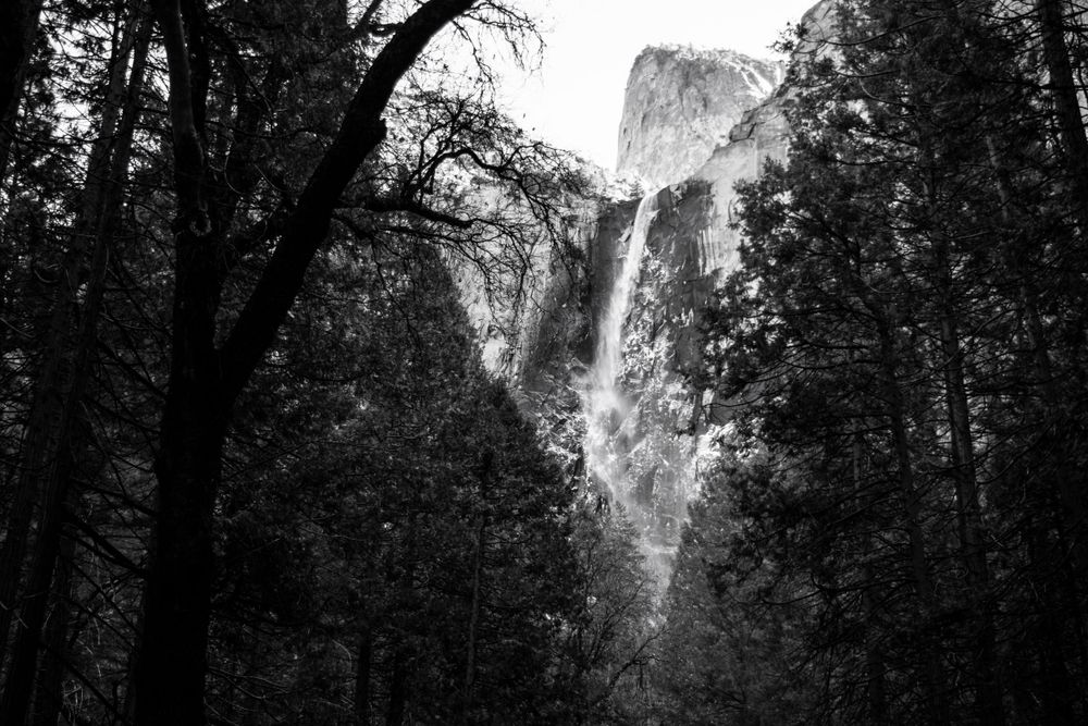 Dramatic black and white view of Bridalveil Falls cascading down granite cliffs in Yosemite National Park.