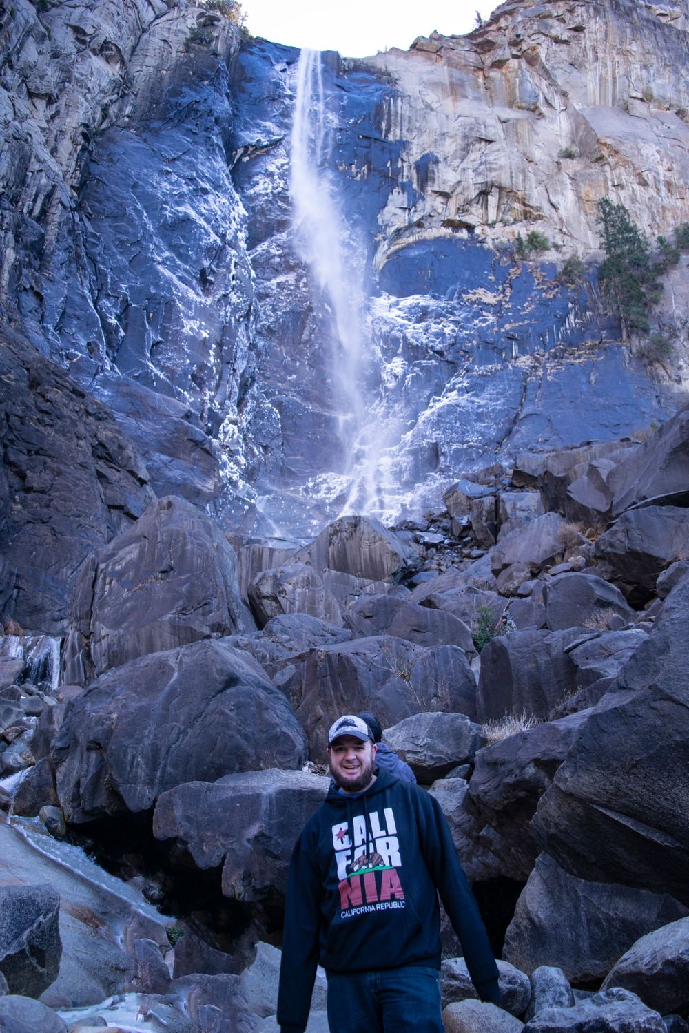 Scenic waterfall cascades down massive granite cliff at Yosemite National Park.