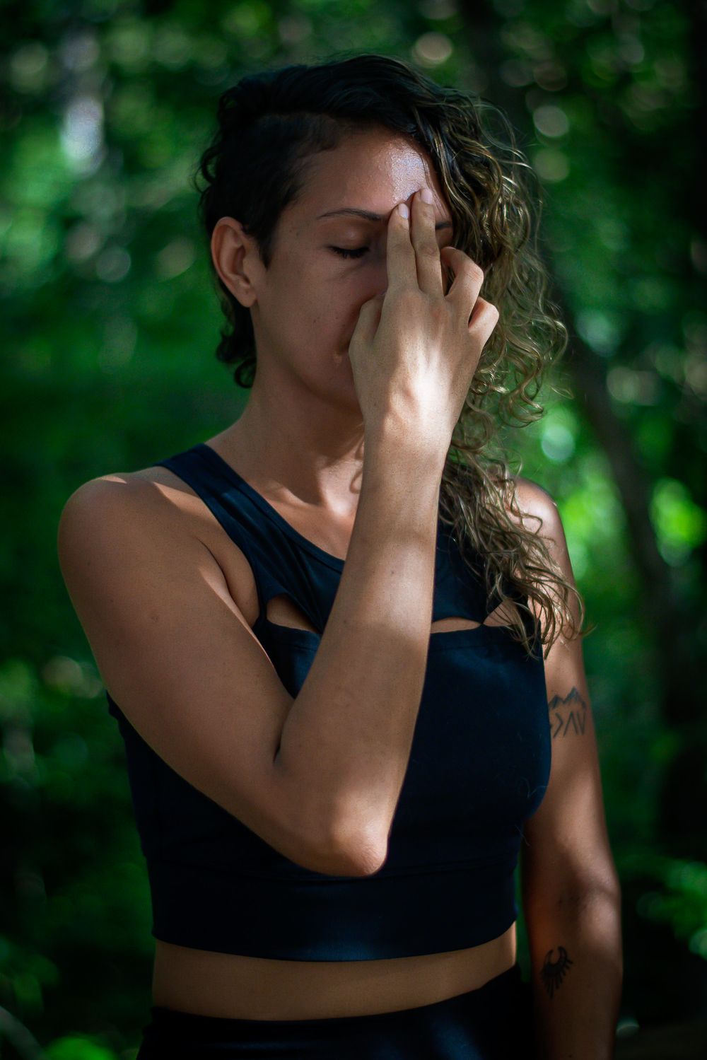 Person in athletic wear practicing pranayama breathing exercise outdoors.