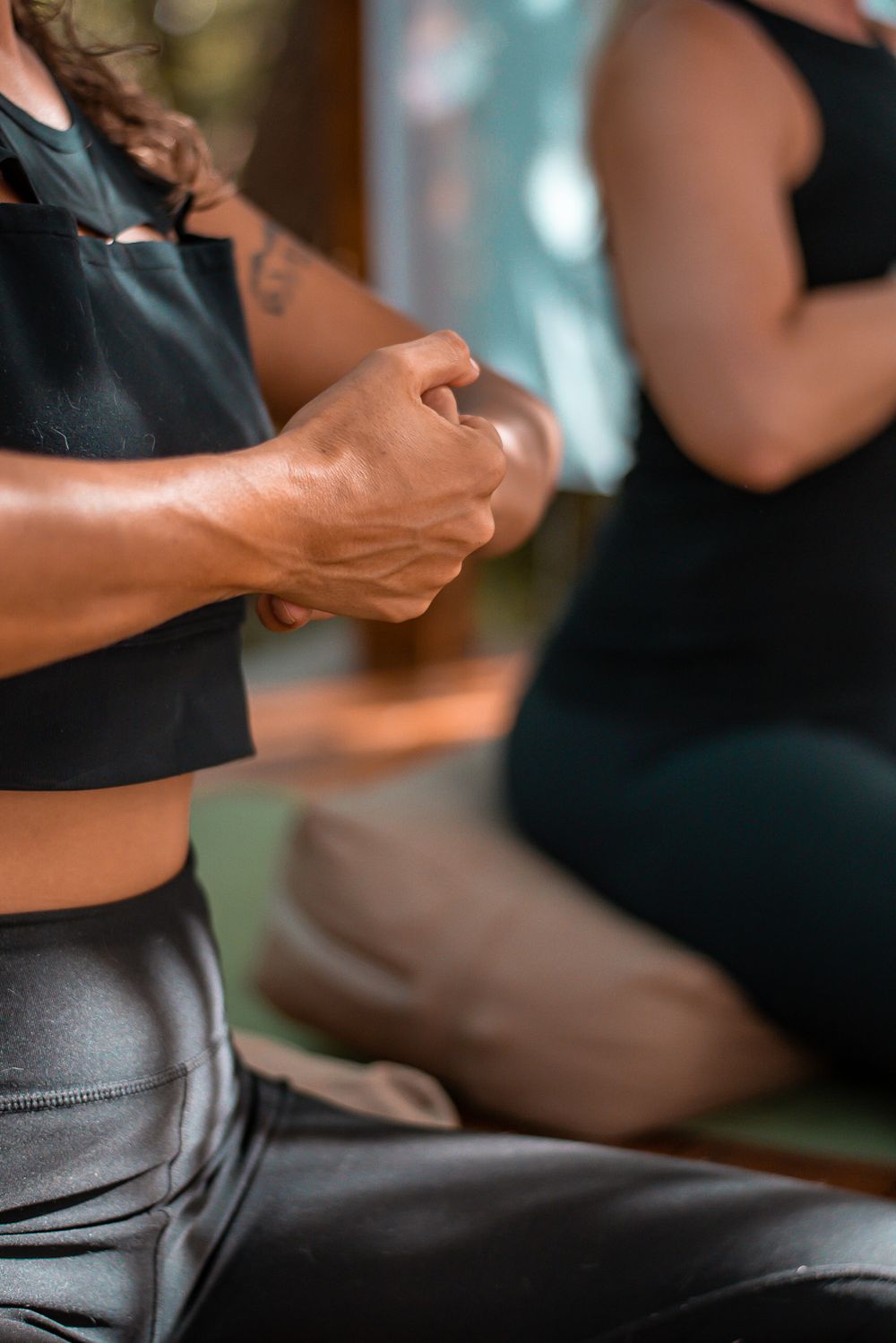 Close-up of hands adjusting athletic wear during yoga practice.