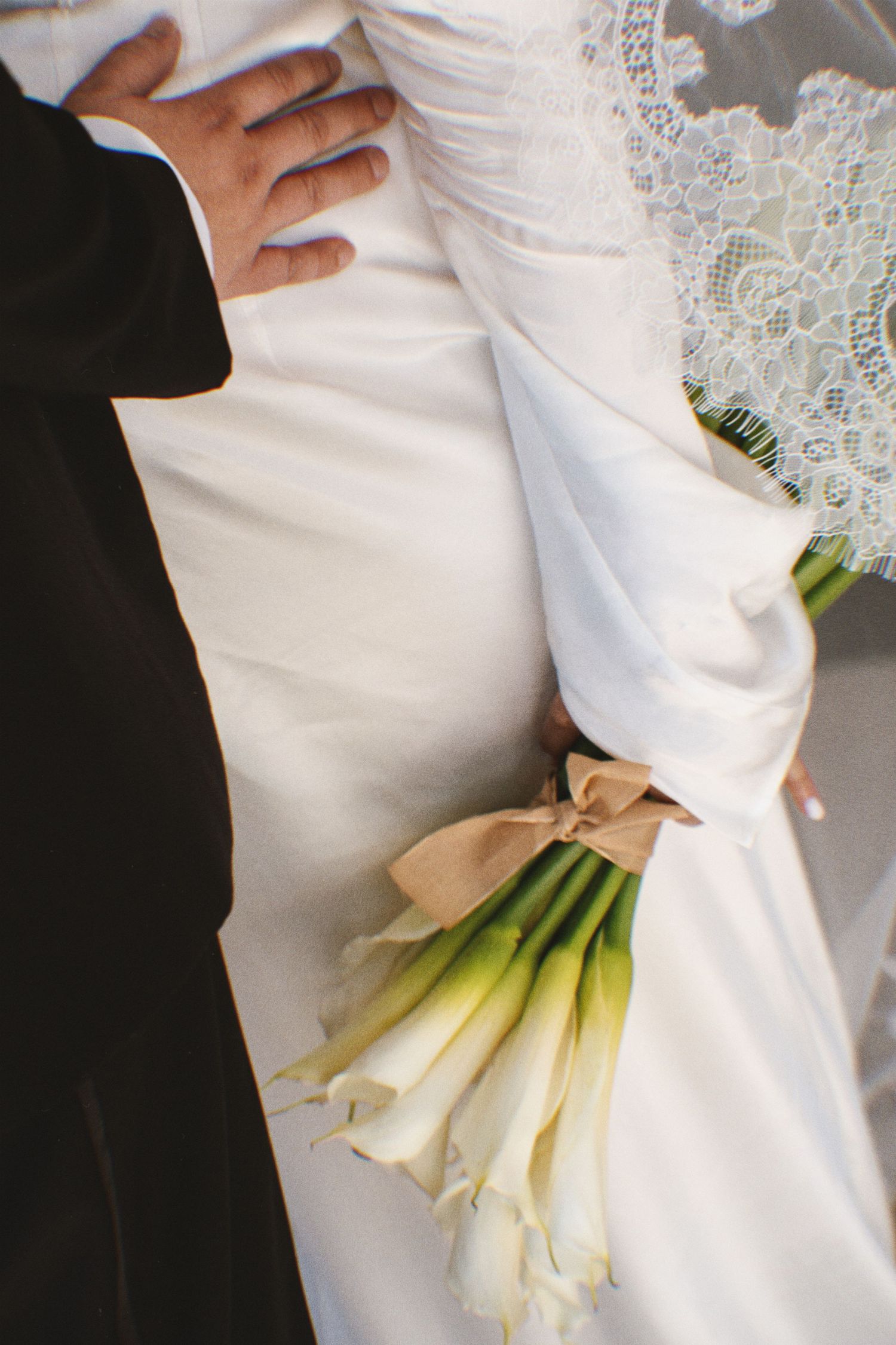 Soft bridal moment - bride holding flowers on a hotel bed, natural light