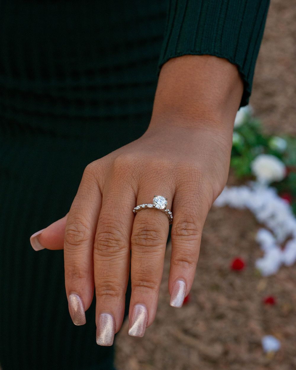 A series of photos showing a hand wearing a solitaire diamond engagement ring on a dark background.