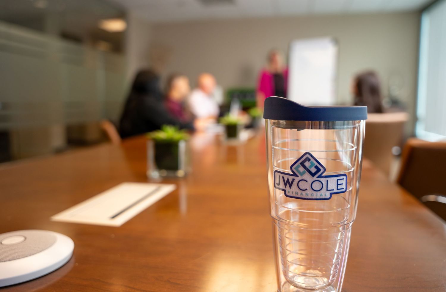 Blurred glassware on wooden table surface in indoor setting.