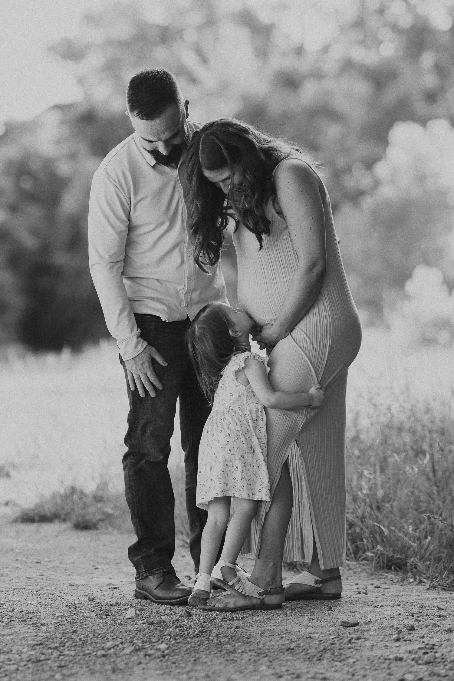 Katie and Kieran with daughter Hailey during golden hour maternity photos on the Katy Trail in St. Charles Missouri