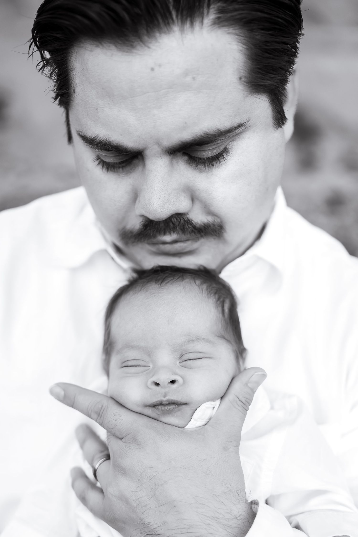 Close up of a father holding his son. Black and white. Doughman Photography.