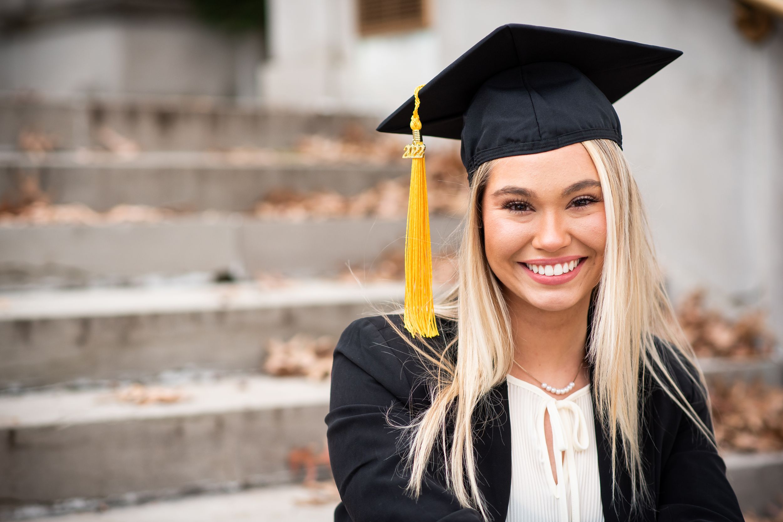 umkc college graduation senior girl with blond hair photo session dressed in grad cap and gown