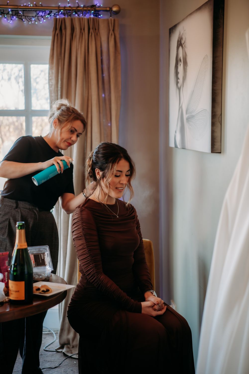 A hairstyling session in progress with warm lighting and brown tones in a cozy home setting.