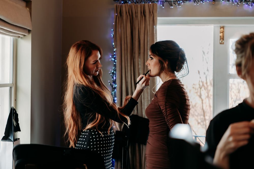 People gathered in a dimly lit room with curtains and decorative lighting during what appears to be a social event.