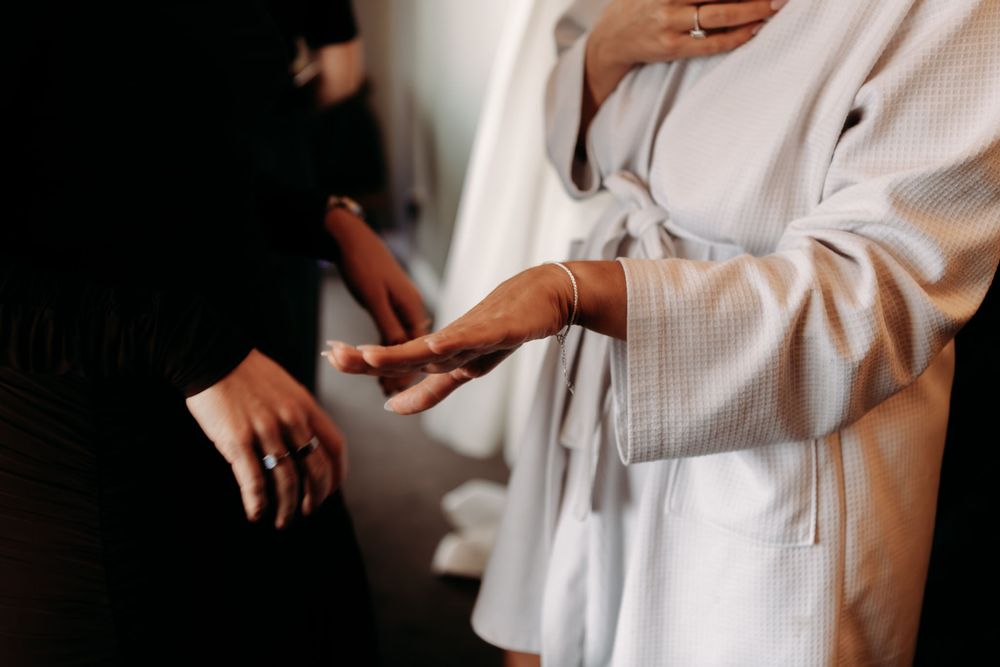 Hands exchanging a white envelope in a professional setting with soft lighting and neutral tones.