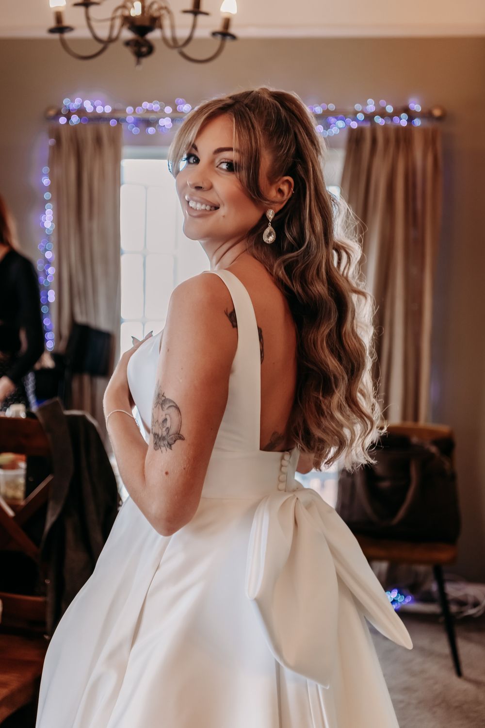 A bride in a classic white wedding dress is photographed from different angles while getting ready for her special day.