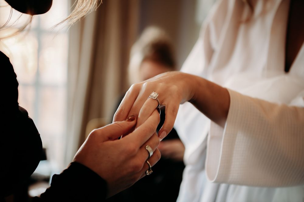 Close-up of hands exchanging wedding rings during a romantic ceremony.