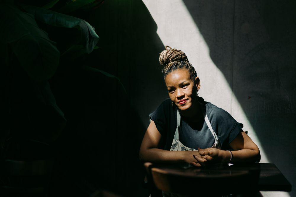 Dramatic shadow and light contrast photo of a person sitting in darkness.