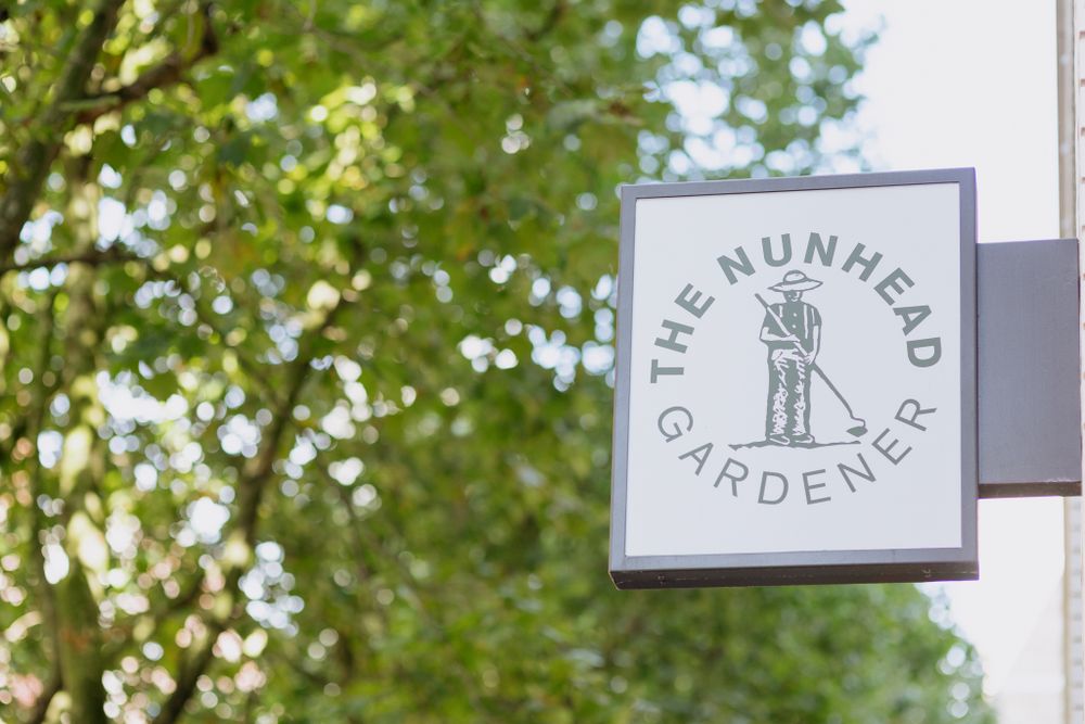 Outdoor restaurant signage and branding visible through green foliage.
