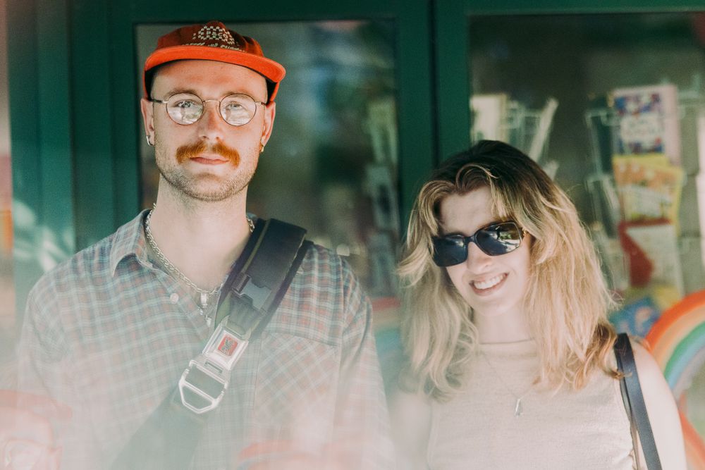 Friends gathered at a restaurant wearing casual attire and sunglasses.