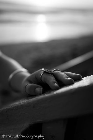 Artistic black and white macro photography of fingers resting on a surface.