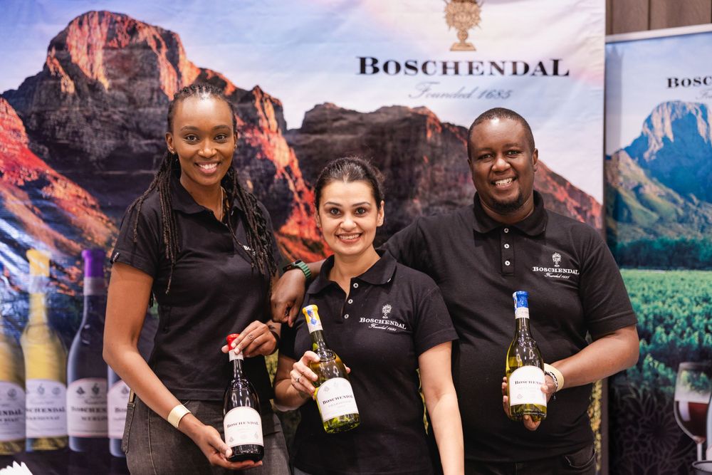 Wines of South Africa event with three members holding wine bottles in Nairobi, Kenya