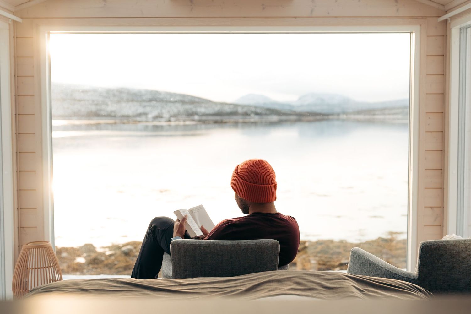 photographie hotel avec une personne qui lit un livre devant les montagnes