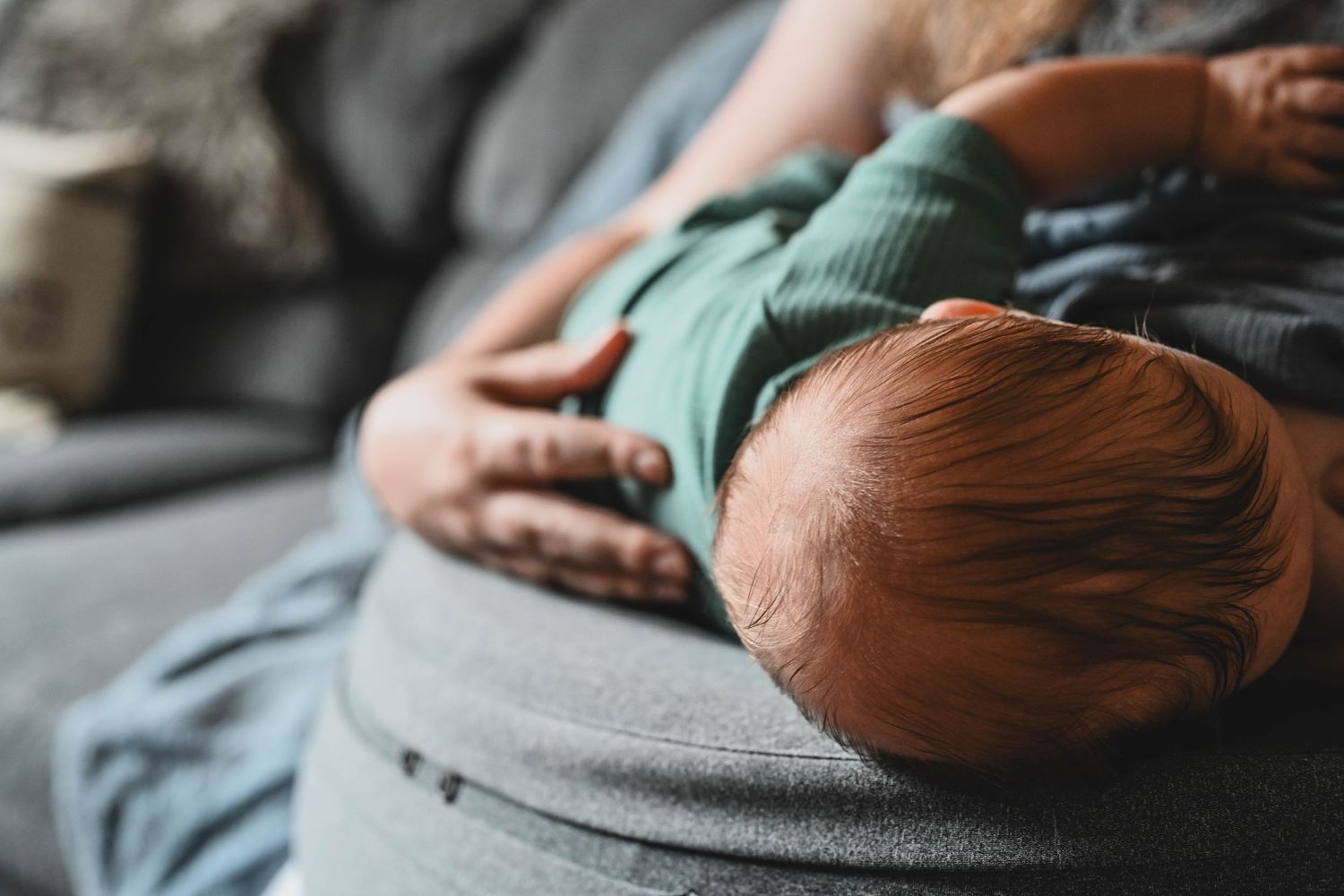 Mom breastfeeds baby during newborn session with Krista Manchuck near Albany, NY