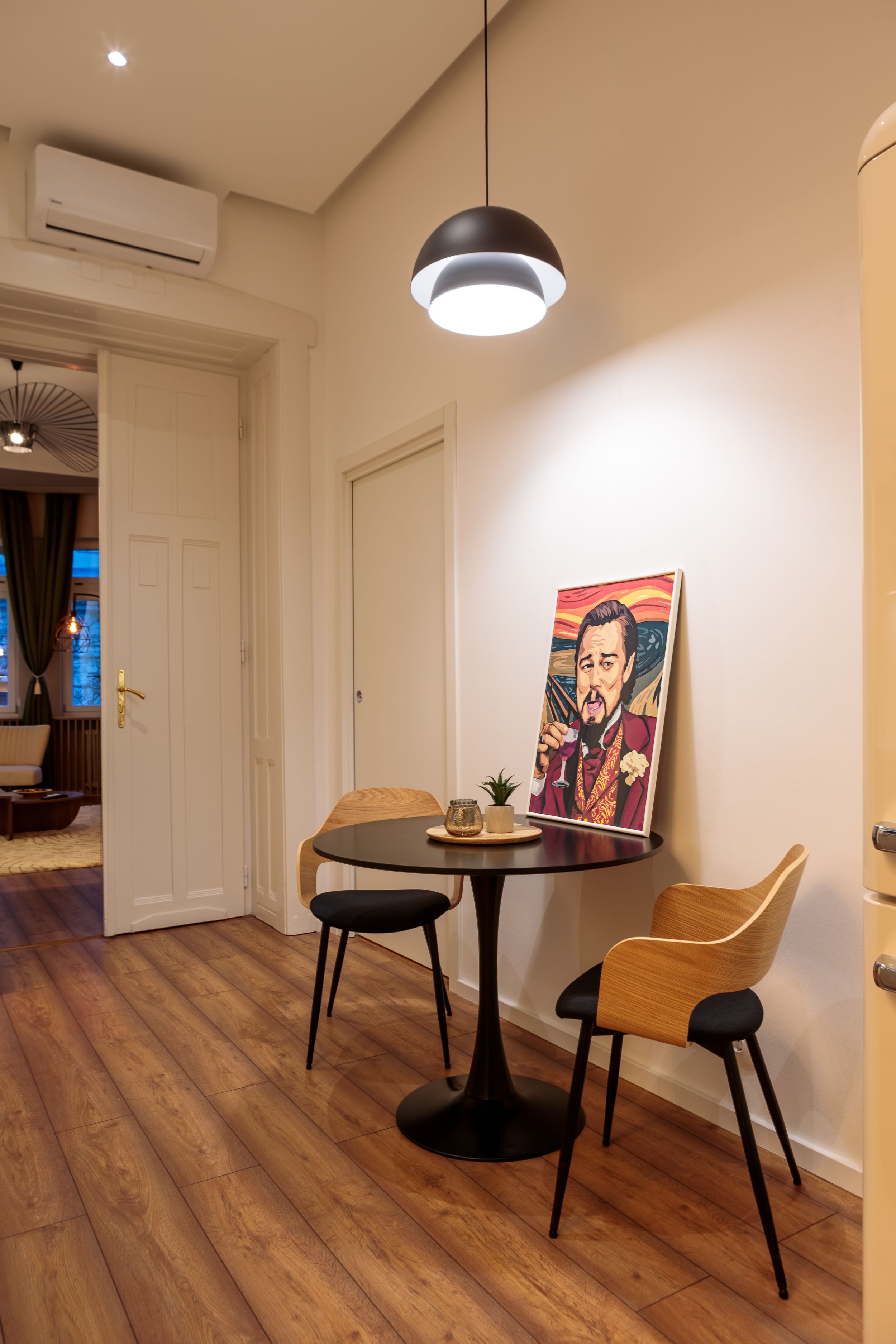 Small dining nook with round table, modern chairs, and pendant lighting.